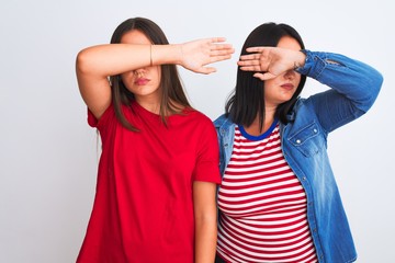 Young beautiful women wearing casual clothes standing over isolated white background covering eyes with arm, looking serious and sad. Sightless, hiding and rejection concept