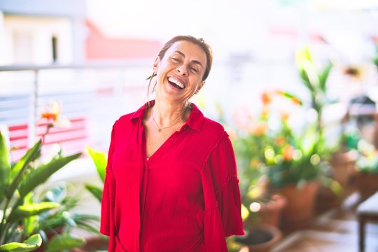 Middle age beautiful woman smiling happy and confident standing with a smile on face at terrace