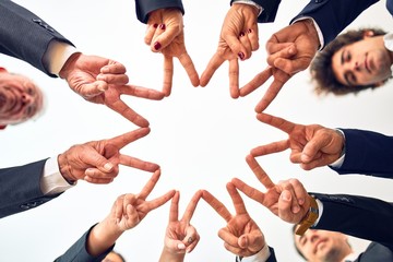 Group of business workers smiling happy and confident. Standing on a circle with smile on face doing symbol with fingers together at the office.