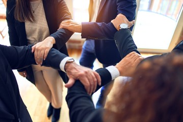 Group of business workers standing on a circle doing symbol with hands and arms together at the office.