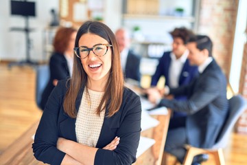 Group of business workers smiling happy and confident working together in a meeting. One of them,...