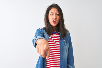 Young chinese woman wearing striped t-shirt and denim shirt over isolated white background pointing displeased and frustrated to the camera, angry and furious with you