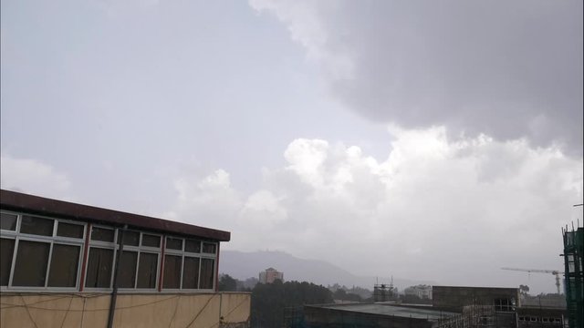 wide shot time laps for arat kilo in Addis Ababa the capital of Ethiopia while the rainy clouds is passing by the city and throw its cargo on the city.