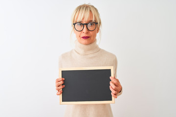 Middle age woman wearing glasses holding blackboard over isolated white background with a confident...