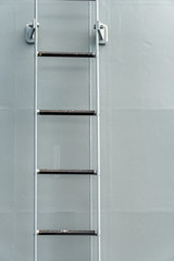 Grey colored fixed type rigid ladder with non skid on the step onboard the warship