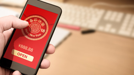 Hand holding smart phone with digital red packet for Chinese new year displayed on the screen