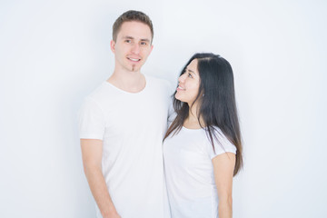 Young beautiful couple standing together over isolated white background