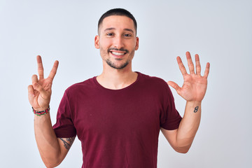 Naklejka premium Young handsome man standing over isolated background showing and pointing up with fingers number seven while smiling confident and happy.