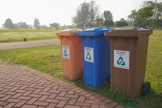 Different colors of recycle bin at public park.