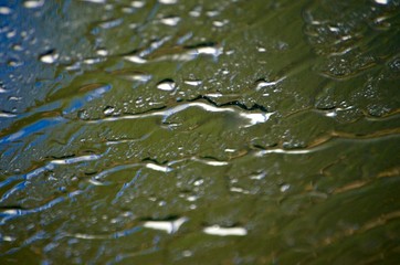 Grey steel water leaks on the glass during the rain.