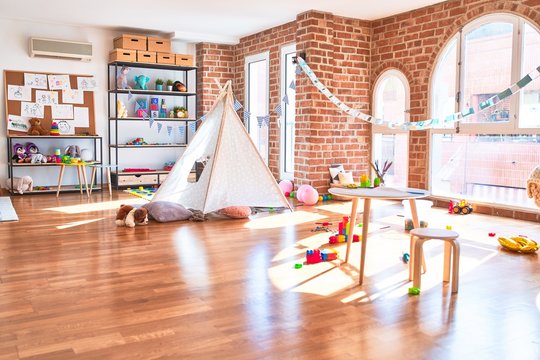 Picture of preschool playroom with colorful furniture and toys around empty kindergarten