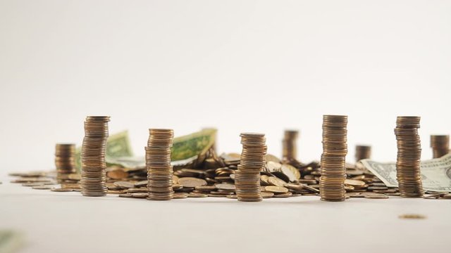 The concept of money. Columns of gold coins in the form of skyscrapers or Stonehenge. Close-up hands make up stacks of coins. Smoke. Garland.