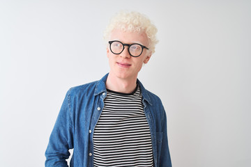 Young albino blond man wearing denim shirt and glasses over isolated white background smiling...