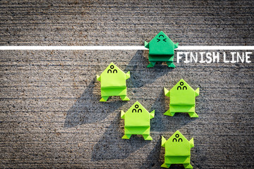 Competition in business or life concept with running origami paper frogs