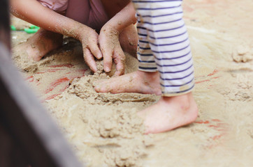 Obraz na płótnie Canvas Kids playing sand in their backyard at home.Kids mess and dirty from sand and mud.Kids activities at home.Simple life.
