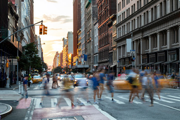 Busy people walk across the crowded intersection on 23rd Street and Fifth Avenue in Manhattan, New York City