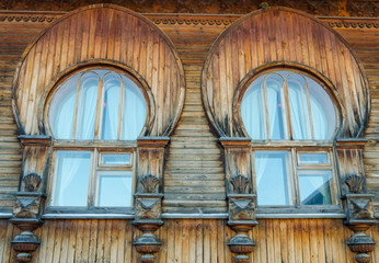 Large arched windows in an old wooden house.