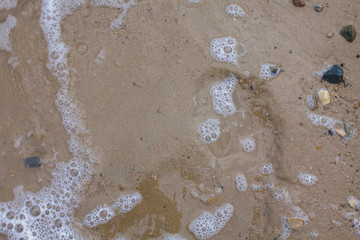 Clean beach with a pech. Sea wave on the shore.