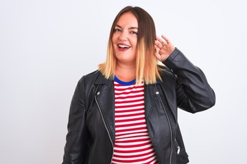 Young beautiful woman wearing striped shirt and jacket over isolated white background smiling with hand over ear listening an hearing to rumor or gossip. Deafness concept.
