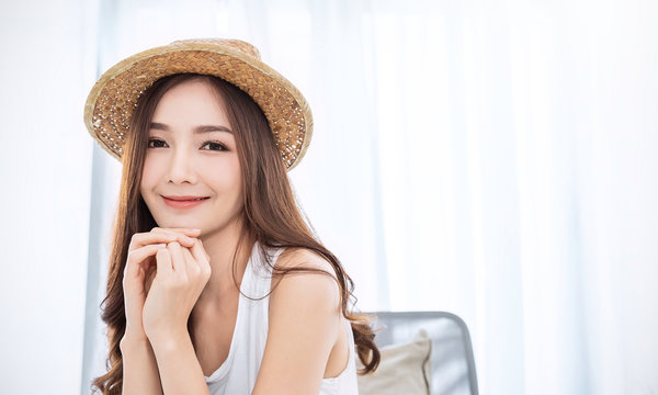 Portrait of young beautiful asian woman on holiday vacation summer time in white bedroom. Happy cheerful relaxing girl in summer. Korean makeup skincare university, woman fashion lifestyle concept.