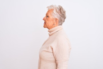 Senior grey-haired woman wearing turtleneck sweater standing over isolated white background looking...