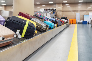Suitcases of different colors on luggage conveyor belt