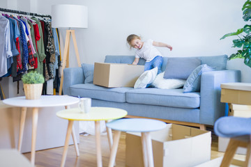 Beautiful toddler child girl jumping on the sofa