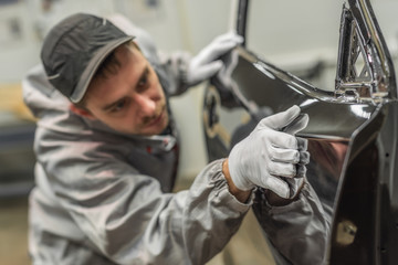 an employee of the body painting workshop checks the quality.
