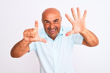 Middle age handsome man wearing casual shirt standing over isolated white background showing and pointing up with fingers number seven while smiling confident and happy.