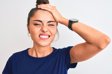 Young beautiful woman wearing blue casual t-shirt standing over isolated white background stressed with hand on head, shocked with shame and surprise face, angry and frustrated. Fear and upset