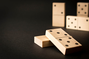 Playing dominoes on a dark background. Leisure games concept. Domino effect. Selective focus.