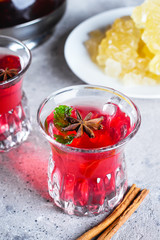 Oriental berry red tea with spices on wooden table background