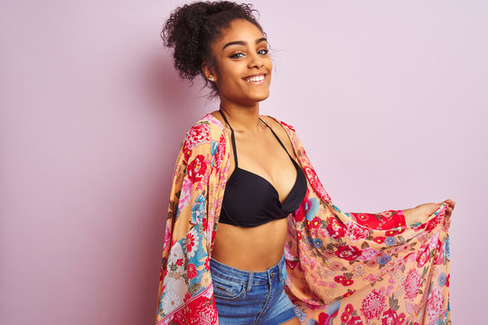 Young beautiful african american woman on vacation standing wearing bikini and colorful caftan