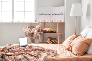 Stylish interior of room with big comfortable bed and autumn decor