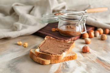 Fresh bread with tasty chocolate paste on table