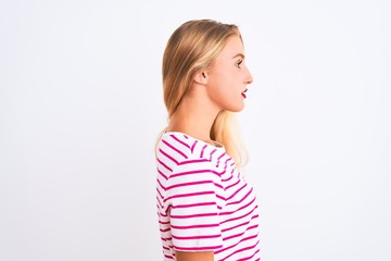 Young beautiful woman wearing pink striped t-shirt standing over isolated white background looking to side, relax profile pose with natural face with confident smile.