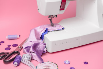 Sewing machine with supplies on color background
