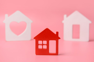 Different figures of houses on color background. Concept of buying real estate