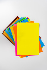 stack of of color paper sheets on the table flat lay, view from above