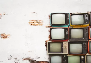  Retro televisions pile on floor in old room with white wall. Antique and vintage home decoration style. © jakkapan