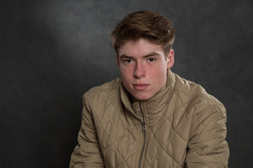 Fototapeta premium Portrait of teenage boy in studio wearing jacket