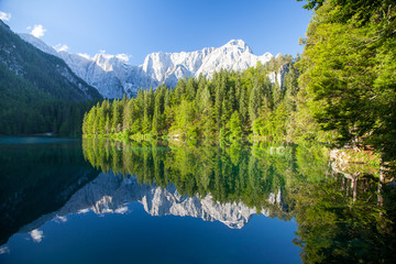 Naklejka na ściany i meble Beautiful morning scene with alpine peaks reflecting in tranquil mountain lake