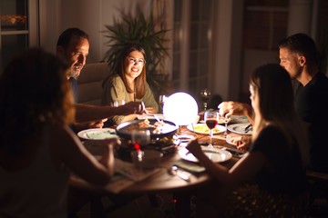 Beautiful family on dinner talking and smiling at terrace