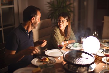 Handsome father and beautiful daughter dinning and smiling at terrace