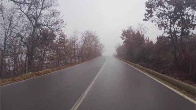 view of the road from the front window of a car on a foggy winter day