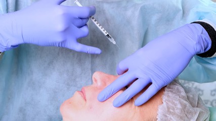 Woman getting cosmetic injection of botox, closeup. Woman in beauty salon. plastic surgery clinic