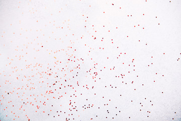 Red glitter on white background. Flat lay, top view.