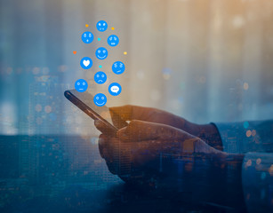 Double exposure of businessman using a social media marketing concept on mobile phone with notification icons of like, chat, message and comment above smartphone screen.