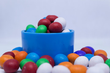 Colorful candies in basket on white background