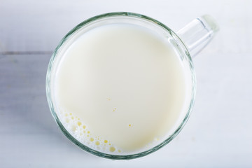Fototapeta na wymiar Glass of milk on wooden background. Top of view.